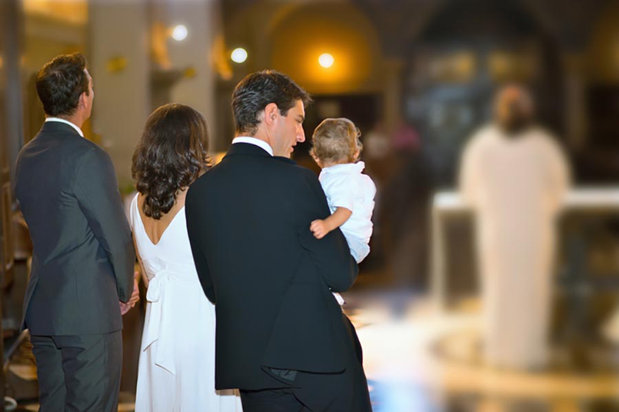 Catholic family in church with adopted baby