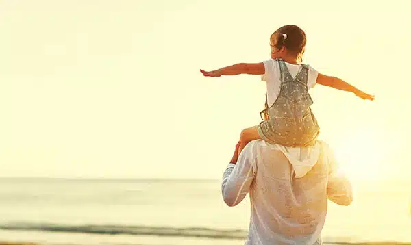 child rides on adoptive dad's shoulders