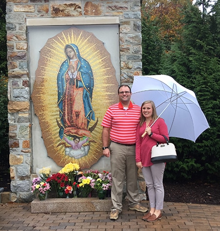PaulBeckygrotto Catholic adoptive couple stand in front of grotto for Blessed Virgin Mary