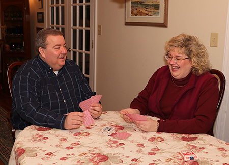 Hopeful Catholic adoptive couple David and Cheryl play cards together laughing